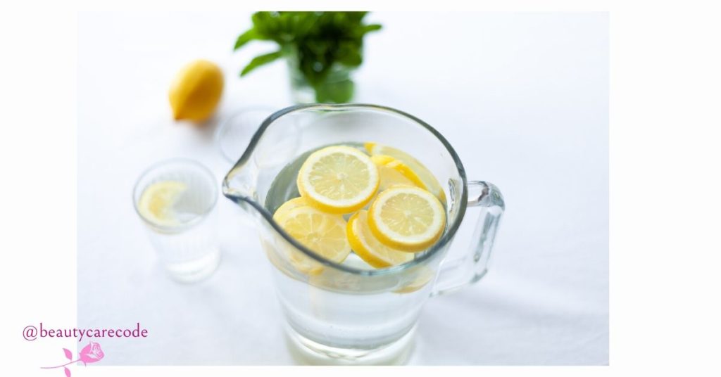 an image of a small jar full of water with slices of lemon in the water to emphasize stay hydrated in how weather