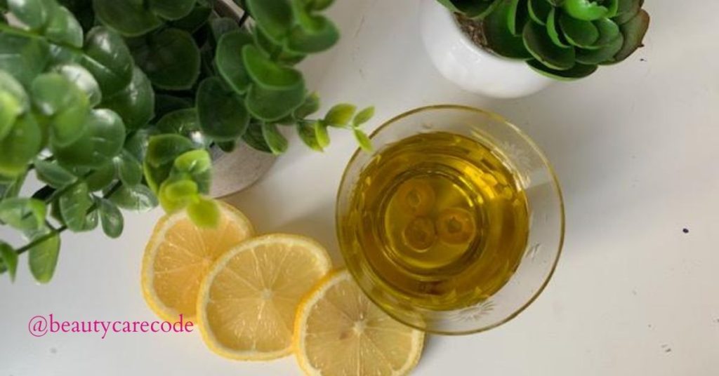 An image of a few slices of lemon and olive oil in a small glass bowl with green plants