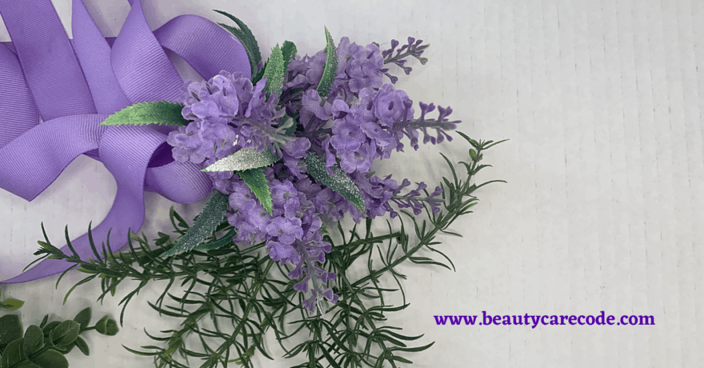 An image of purple flower and ribbon with green leaves in a white background to discuss about magic herbs for your sensitive skin